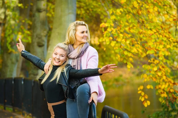 秋の公園を歩くファッショナブルな衣装を着た二人のブロンド女性 — ストック写真