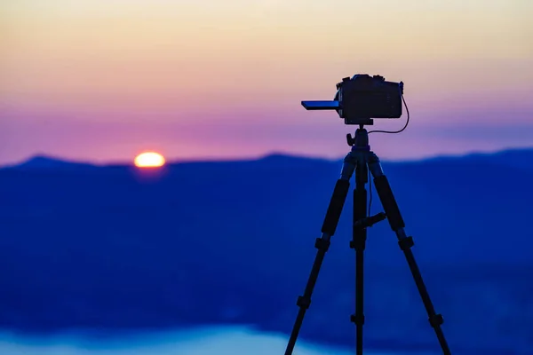 三脚架上的专业相机拍摄落日在海面上的影像 — 图库照片