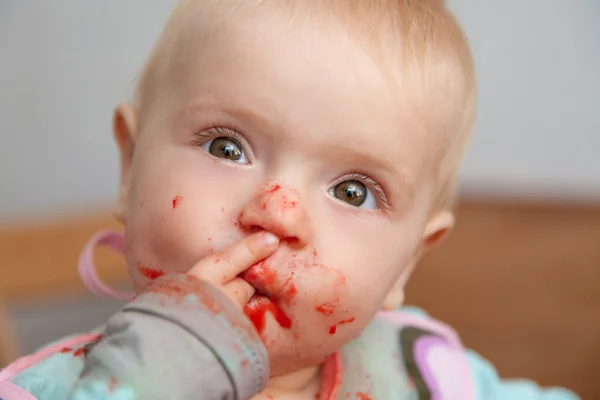 Baby girl eating, dirty face — Stock Photo, Image