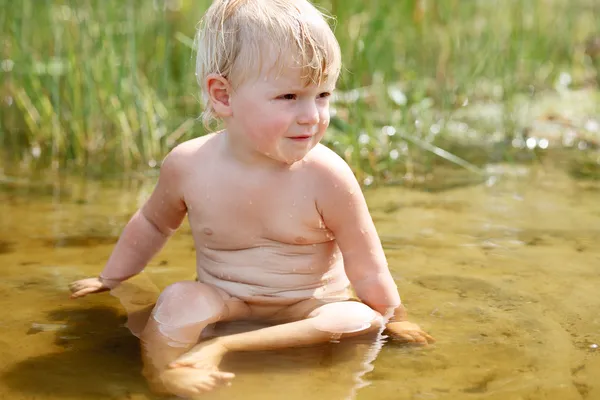 Little girl sitting in river — Stock Photo, Image