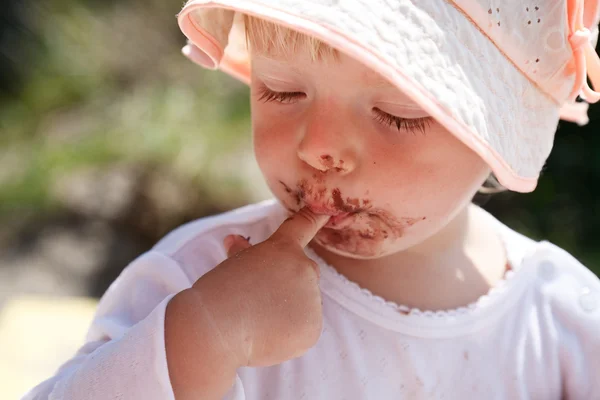 Little girl eating chocolate — Stock Photo, Image