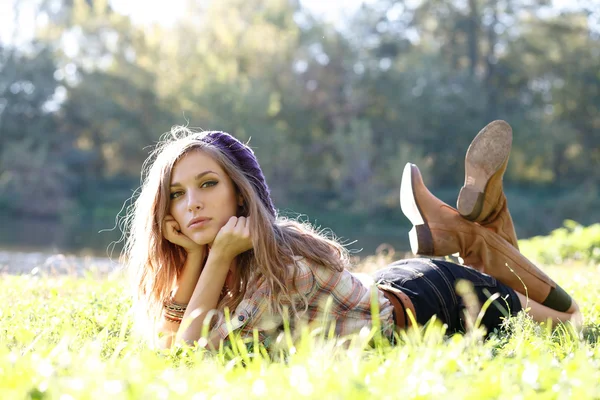 Güzel genç bir kadın çimenlerde yatıyor. — Stok fotoğraf