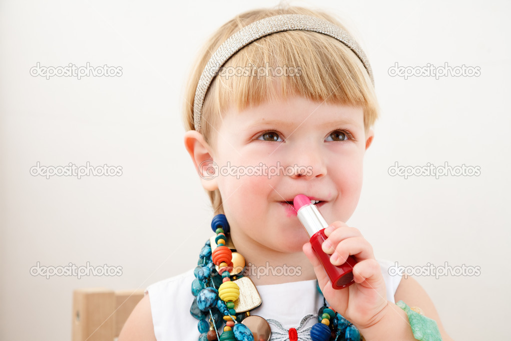 little girl applying lipstick