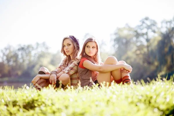 Due ragazze sedute schiena contro schiena — Foto Stock