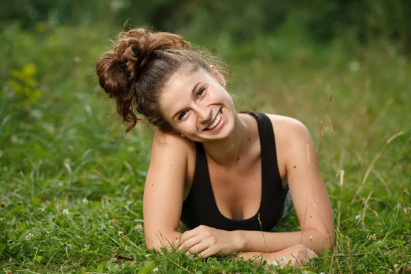 Tânără femeie întinsă pe iarbă — Fotografie, imagine de stoc