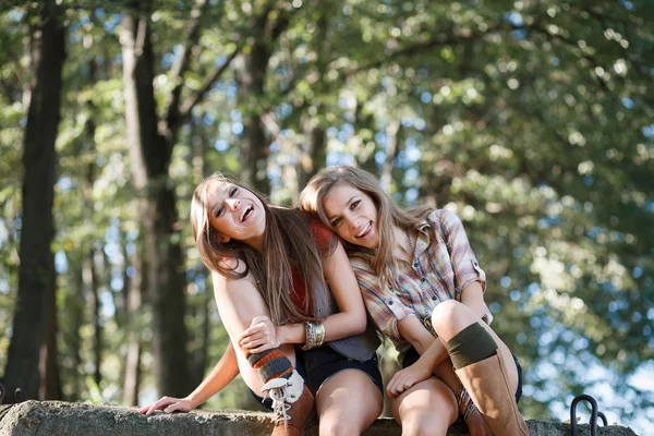 Две сидящие смеющиеся женщины — стоковое фото
