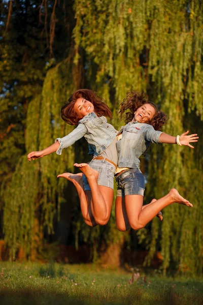 Due ragazze adolescenti saltando — Foto Stock