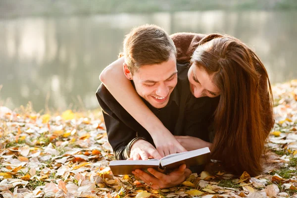 Pareja joven acostada leyendo —  Fotos de Stock