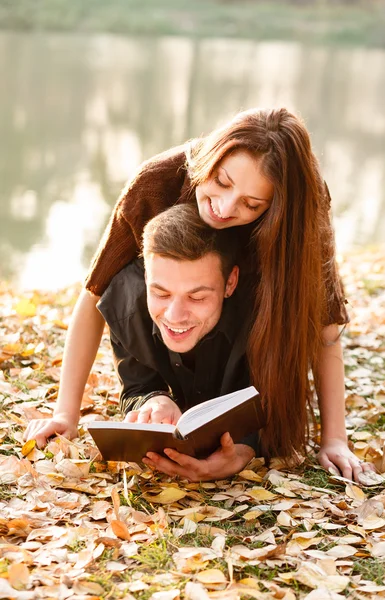 Giovane coppia sdraiata lettura — Foto Stock