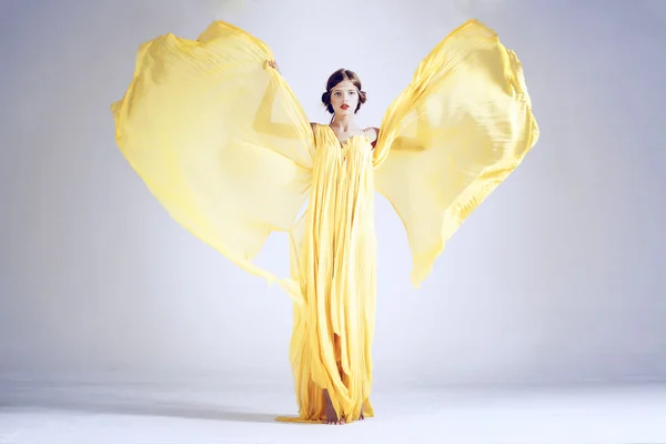Meisje model in de uitbreiding van gele jurk — Stockfoto