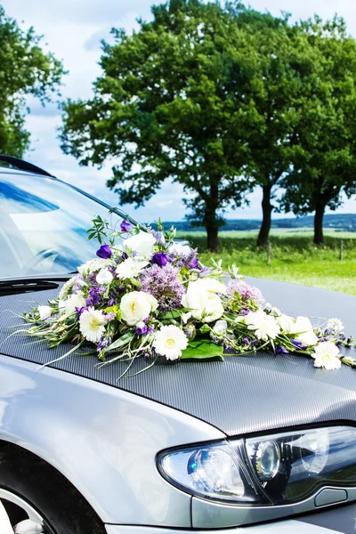 Bröllopsbil dekorerad med blommor Stockbild