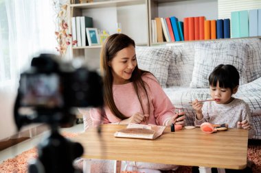 Genç ve güzel anne, küçük kızının yüzünü tarıyor. Günlük tutma ve ebeveynlik kavramı