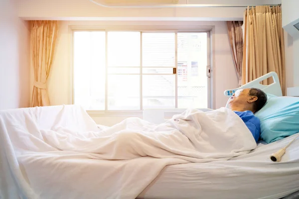 一个戴眼罩的老人 病人躺在病床上 医疗上模糊的内部背景 白色房间 — 图库照片