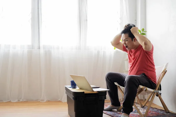 Asian male businessman with stressful headaches from working on his desk.