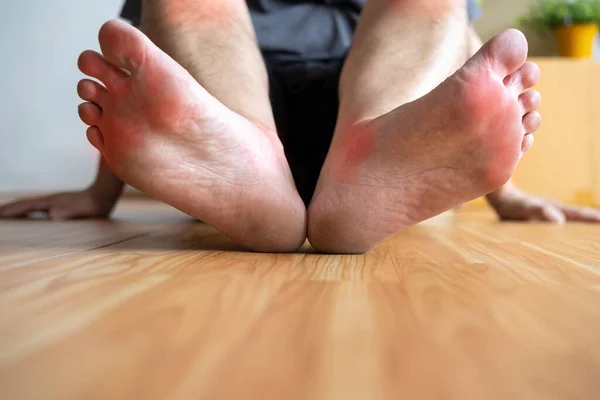 Pain in the foot, foot massage, cramp, muscular spasm, red accent on the foot, close-up