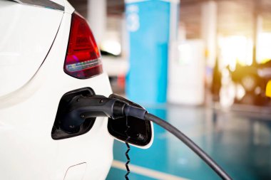  Çevre dostu alternatif enerji kavramı. Otoparkta şarj aleti olan elektrikli bir arabayı şarj etmek.