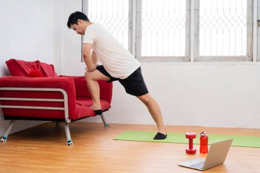T-shirt ve Şort Güçlü Atletik Fit Man Enerjik Minimalist İç ile Onun Geniş ve Parlak Oturma Odasında Evde Yerinde Jogging olduğunu.