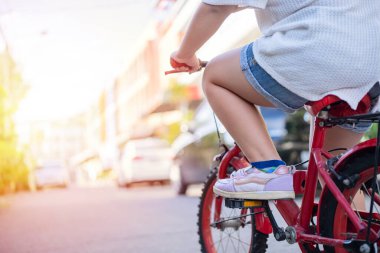 Bisikletinin üzerine monte edilmiş bir çocuğun bacakları yere boyanmış beyaz bir ok işaretinin yanına oturmaya hazırdı. Kavram İlerlemeye devam et.
