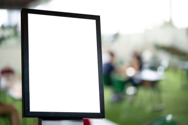 Restoranın önünde beyaz poster ya da beyaz kağıt tanıtımı sergileniyor. Pazarlama duyuruları ve detaylar için kahve dükkanının tanıtım bilgileri.