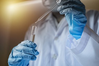 Laboratuvarda araştırma yapan bilim adamları. Cam bölmeye odaklanmış kadın yaşam bilimi profesyonel pipet çözeltisi. Mercek araştırmacının gözlerine odaklanıyor. Sağlık ve biyoteknoloji kavramı.