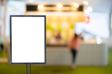Promosyon ürün konsepti için siyah çerçeveli model beyaz afiş bulanık restoran kafesinin arka planında