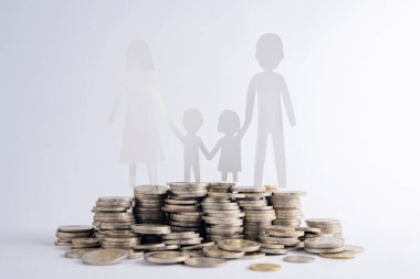 Para yığını ve ailenin kağıt kesiği ahşap masa, doğa geçmişi, evlilik hayatına başlamak için para biriktirme, inşaat ya da finansal istikrar, aile planlaması.