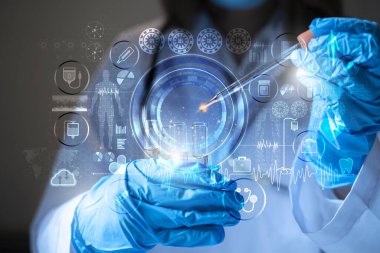 Fütüristik bir laboratuvarda, pipetli bir bilim adamı DNA 'yı ve test tüplerindeki molekülleri ayırmak için renkli bir sıvıyı analiz eder..