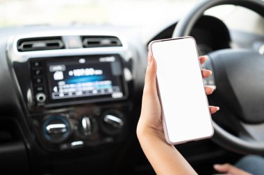 Cep telefonu kullanan bir kadın navigatör başvurusuyla adresi kontrol ediyor, araba kullanıyor. Sürücü el ele tutuşup bir arabanın içindeki cep telefonuna bakıyor, beyaz ekran modeli.