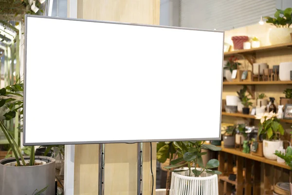 LCD television screen in a grocery store. green tree trunk background. LCD Blank billboard for copy space in your text message or promotional content