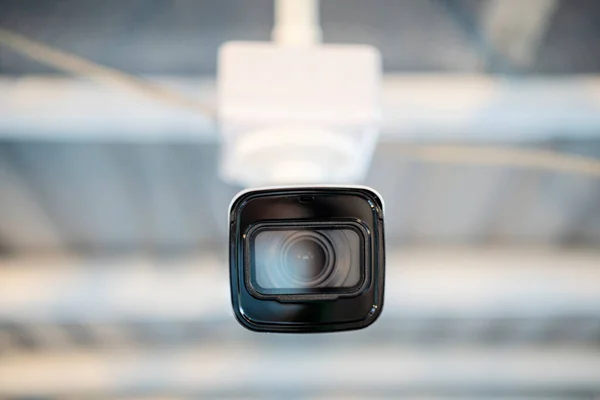 现代闭路电视摄影机在墙上 一个模糊的夜城市背景 监视和监视的概念 色调图像双曝光模拟 — 图库照片