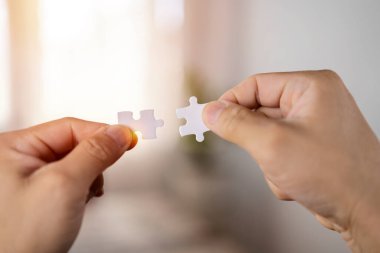 Yapboz ile güneş ışığı efektini birbirine bağlayan kadın eli, iş çözümleri, başarı ve strateji kavramı