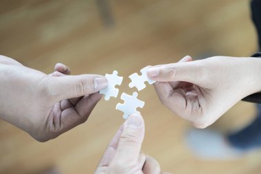 Kağıt yapboz rahat ekose gömlek giymiş iş adamları el ele tutuşup çözme bulmaca, yapboz, bulmacanın parçaları bir araya koymak isteyen iş grup montaj iş takım.