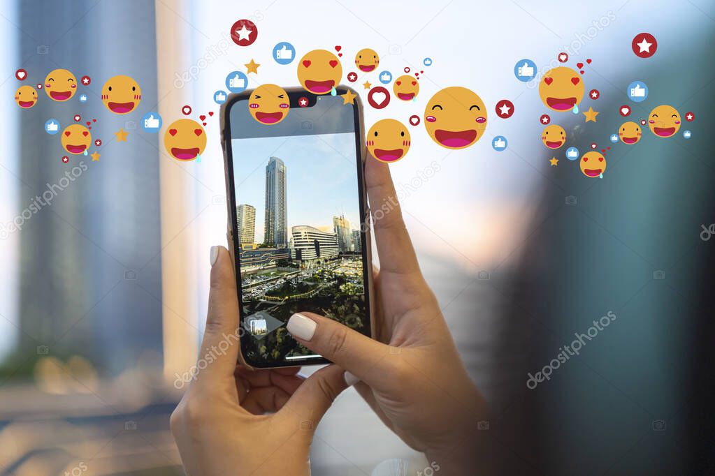 Girl vlogger using a smartphone to take photos and post on social media gets tons of likes from the emoji above the close-up view.