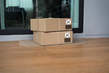 Ekspres paket servis konsepti, paket kutusu giriş kapısının yanındaki paspasın üzerindeki el işi kağıdına sarılı..
