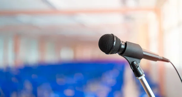 Close up of microphone in concert hall or conference room. Microphone on stage against a background of auditorium