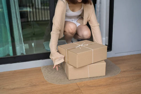 Woman pick up the parcel box to door contactless delivery during a pandemic covid. Online shopping, Quarantine.