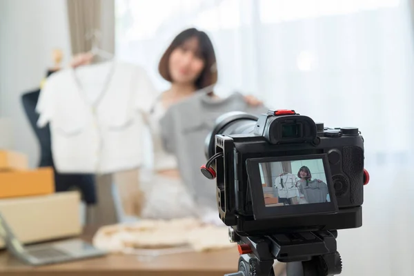 年轻而美丽的亚洲女性博主在智能手机相机前展示服装 同时记录Vlog视频和现场流媒体 — 图库照片