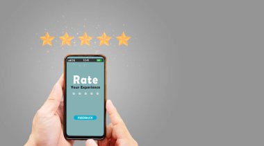 Müşteri Geribildirim Konsepti: Gri arkaplanda en iyi servis sıralamasını veren sarı beş yıldızı gösteren akıllı telefon.