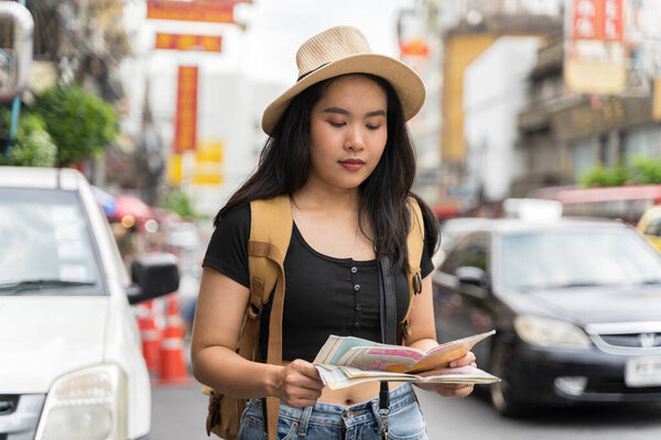 Young asian travel girls are enjoying with beautiful place in bangkok, thailand. traveler searching direction on location map while traveling