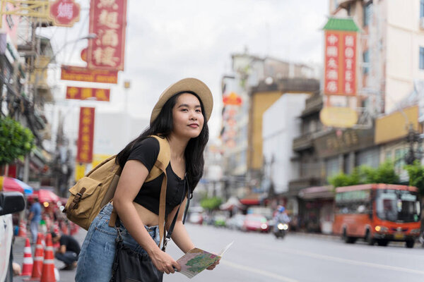 Young asian travel girls are enjoying with beautiful place in bangkok, thailand. traveler searching direction on location map while traveling