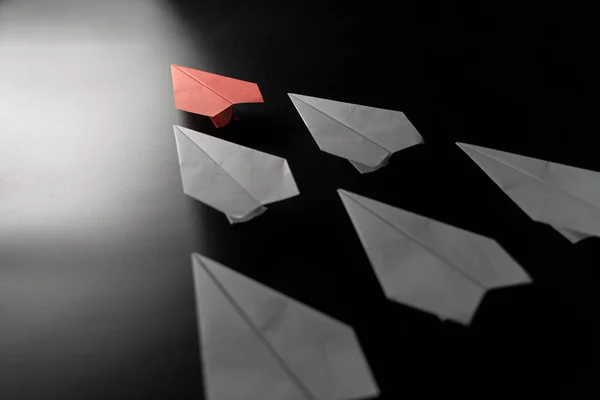 Different thinking concept. Red paper plane leaving the group. Red paper plane leading white ones, leadership