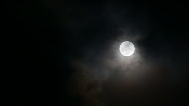 Bulutlar dolunayda hareket ediyor, atmosfer gizemli ve korkutucu görünüyor. 4K video.