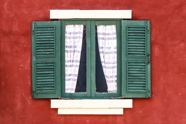 Oude groen raam met gordijn op rode muur — Stockfoto