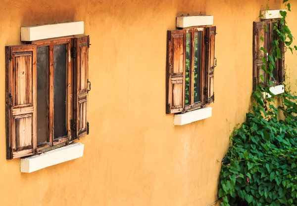 Vieja ventana de madera en la pared amarilla — Foto de Stock