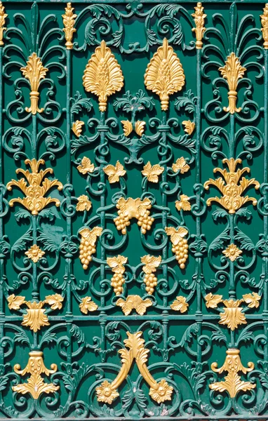 Gebogenes Stahlmuster auf grünem Tor mit goldenen Strukturen — Stockfoto