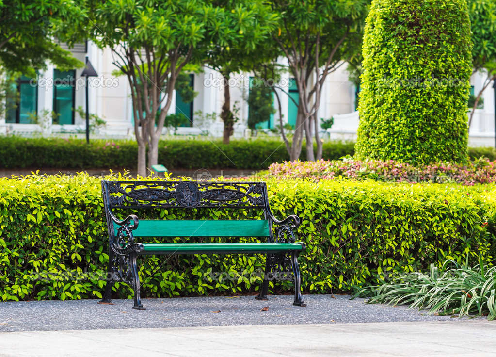 Green Bench In The Park With White Building Background Stock