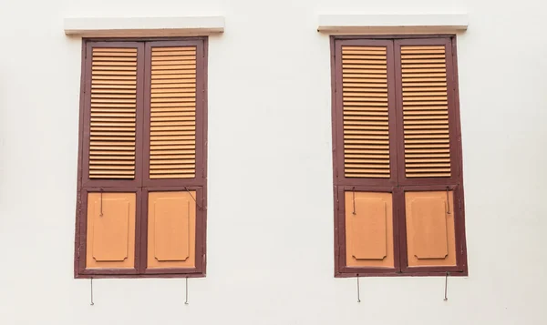 Twee houten ramen op gewone muur — Stockfoto