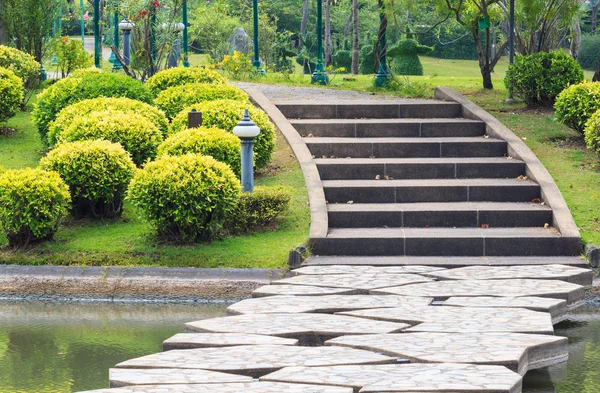 Gehweg über den See führt zu Betonstufen durch den Park — Stockfoto