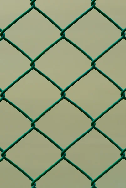 Cerca de arame verde isolado no fundo marrom, padrão vertical — Fotografia de Stock