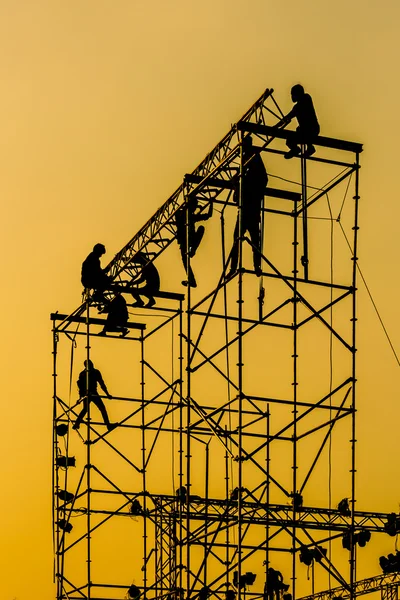 Silhuett av workmen på montering konsert scenen — Stockfoto